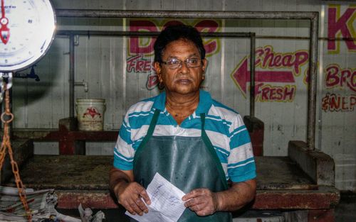 Fisherman holding paper while standing at store