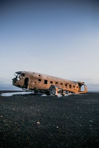 Abandoned airplane on airport runway against sky