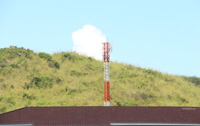 Communications tower on field against clear sky