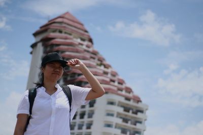 Low angle view of woman standing against built structure