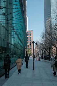 Rear view of people walking in city