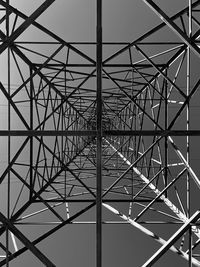 Symmetric low angle view of pylon tower against sky