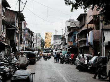 People walking on mahatma gandhi road amidst buildings against sky