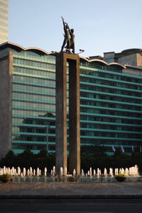 Low angle view of birds perching on building against sky