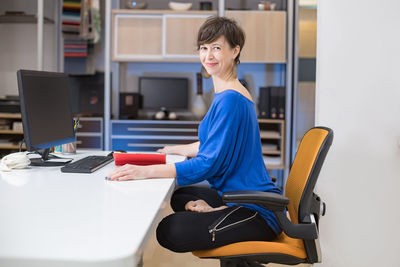 Portrait of young woman sitting on chair