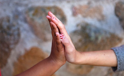 Close-up of girls hands giving high-five