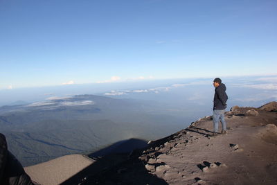 Man looking at mountain against sky