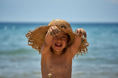 Close-up of shirtless young woman against sea