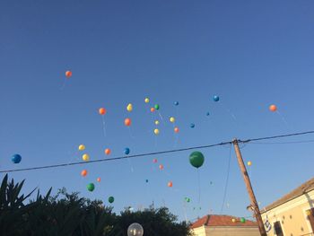 Low angle view of balloons against blue sky