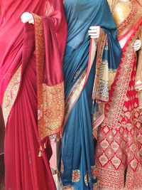 Midsection of woman standing by multi colored umbrella