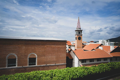 Tower amidst buildings in city against sky