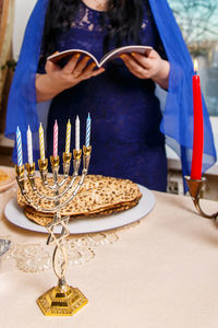 Midsection of woman with drink on table