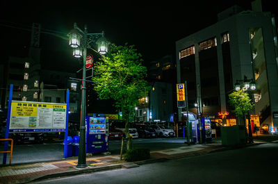 Illuminated city street against sky at night