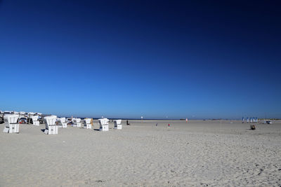 Scenic view of beach against clear blue sky