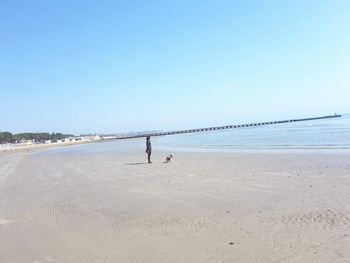 Man on beach against clear blue sky