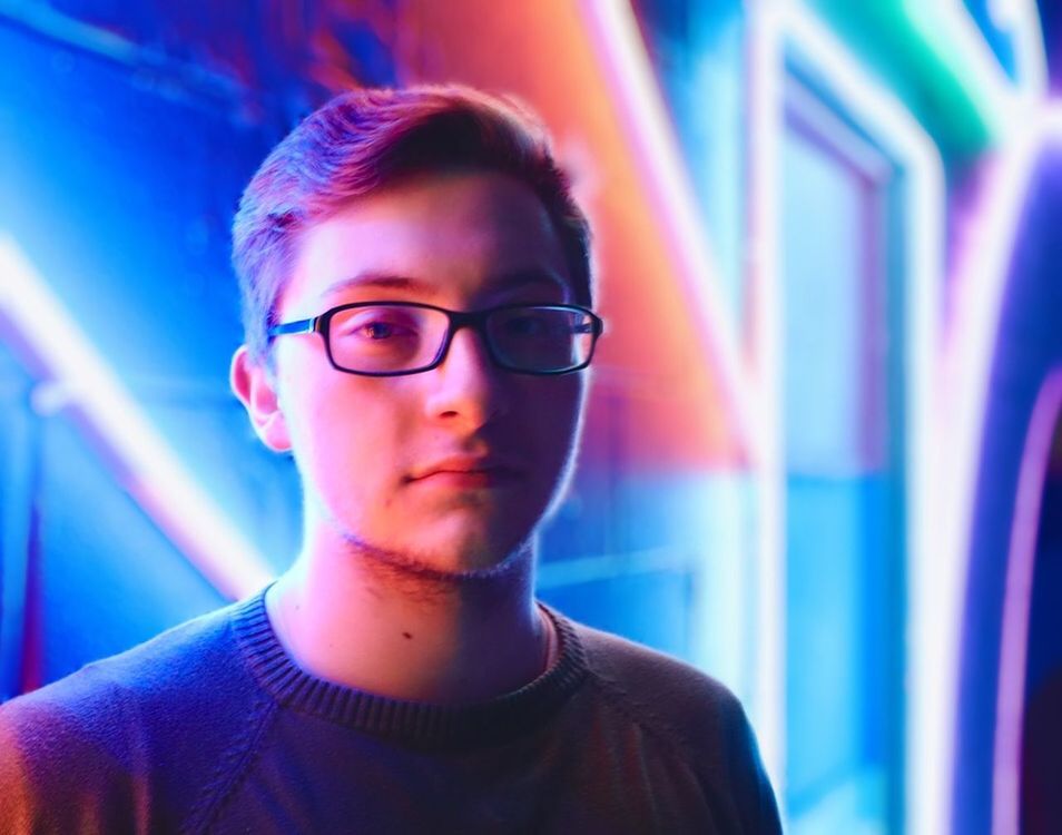 CLOSE-UP PORTRAIT OF YOUNG MAN WEARING EYEGLASSES