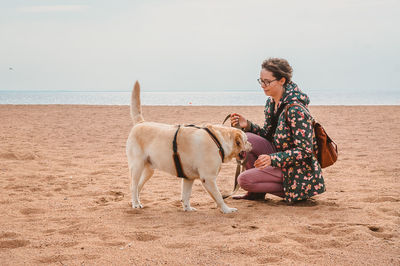 Full length of woman with dog on beach