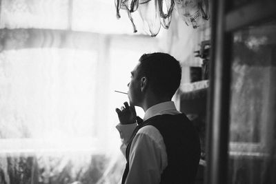 Side view of young man smoking cigarette