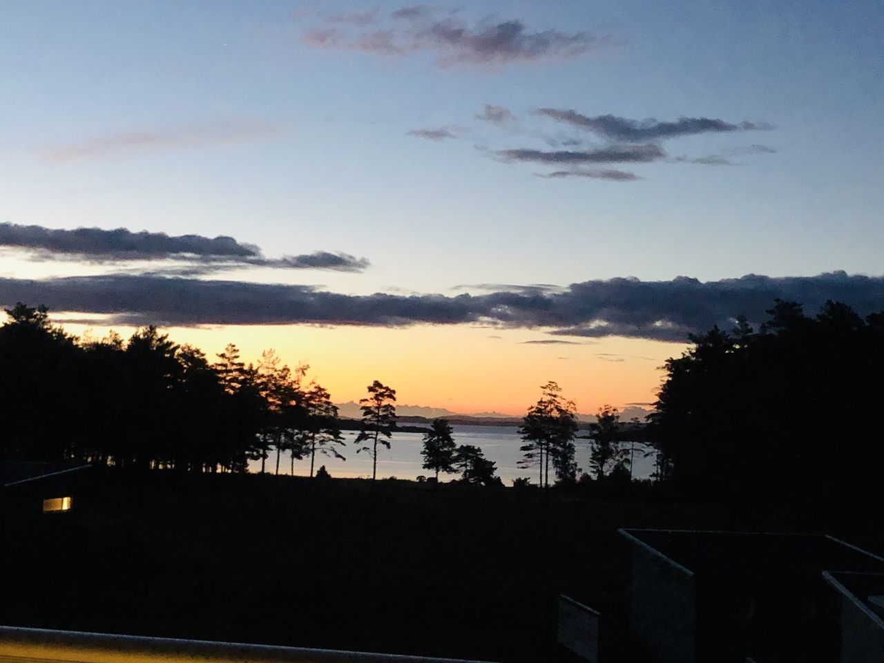 SILHOUETTE TREES BY LAKE AGAINST SKY AT SUNSET