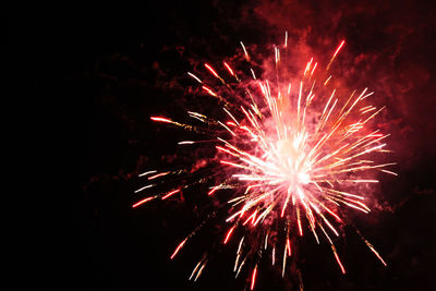 Low angle view of firework display at night