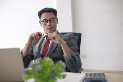 Young man using mobile phone while sitting on table