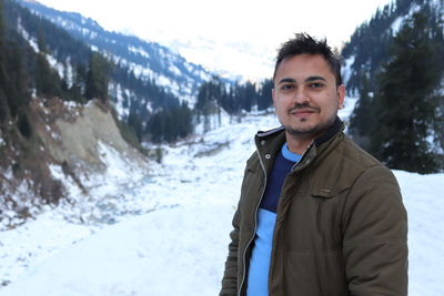 Portrait of young man standing in snow