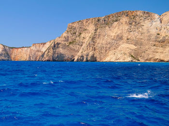 Scenic view of sea by rocky cliff