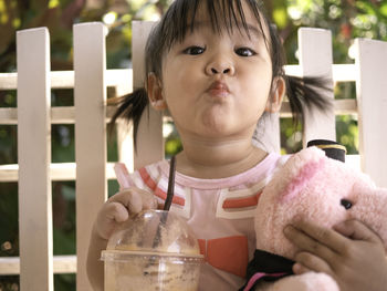 Portrait of cute girl drinking smoothie at cafe