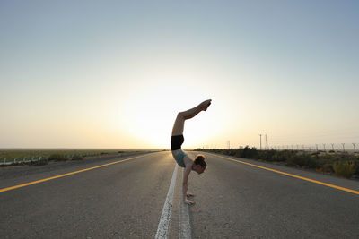 Girl doing a handstand in the road 