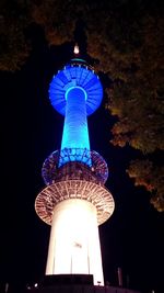 Low angle view of illuminated communications tower at night