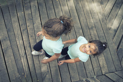 High angle view of cute baby girl on hardwood floor