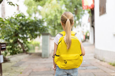 Schoolgirl back to school after summer vacations. happy child smiling early morning outdoor.