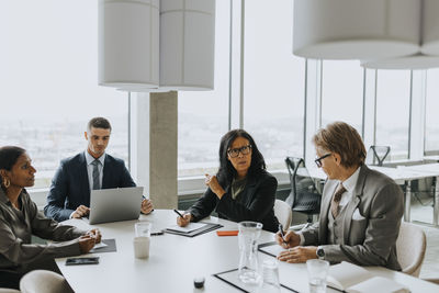 Multiracial business colleagues discussing strategy in board room