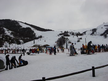 People on snow covered mountain against sky