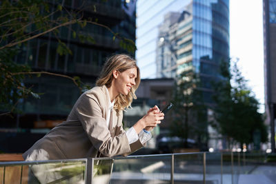 Businesswoman using mobile phone in city