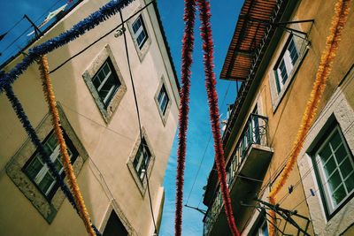 Low angle view of colorful decorations hanging against buildings