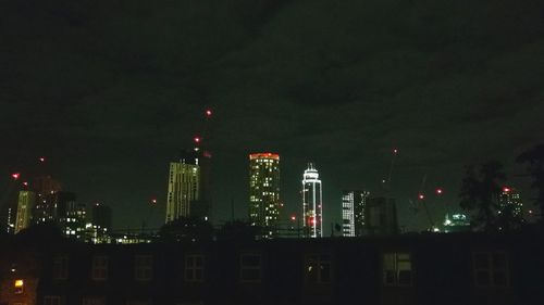 Illuminated buildings against sky at night