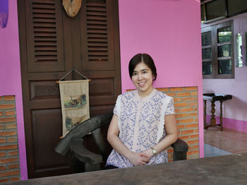 Portrait of a smiling young woman sitting on seat