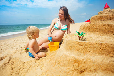 Rear view of woman sitting on beach