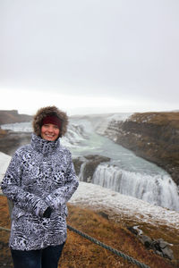 Portrait of smiling woman standing on snow covered land