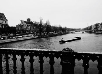 Bridge over river in city against clear sky