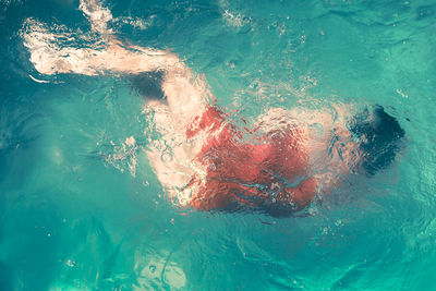 Full length of woman swimming in blue sea