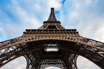 Low angle view of eiffel tower against cloudy sky