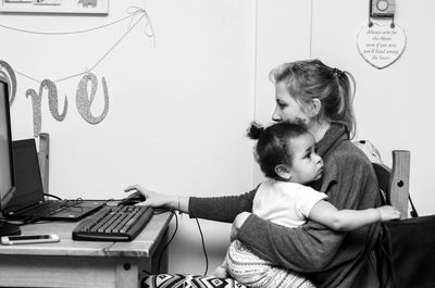 Woman working while sitting with daughter at home