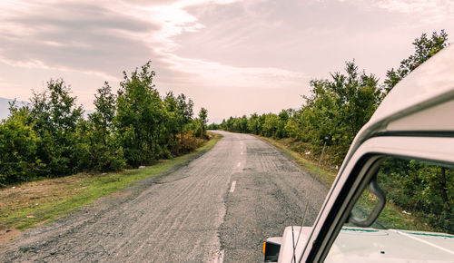 Road amidst trees against sky