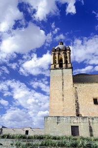 Low angle view of bell tower against cloudy sky