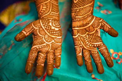 Midsection of bride showing henna tattoo