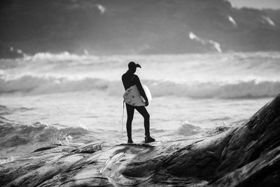 Full length of man standing on beach against sky