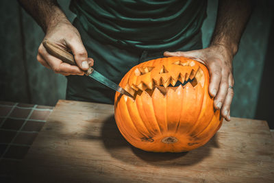 Midsection of man holding pumpkin