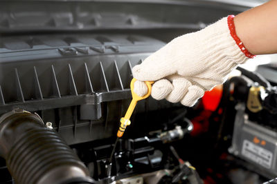 Car mechanic checking engine oil before leaving